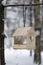 a wooden bird feeder in a snowy forest at winter