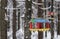 A wooden bird feeder in a snowy forest at winter