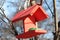 Wooden birdfeeder with roof for birds and animals in the city park