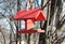 Wooden birdfeeder with roof for birds and animals in the city park