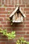 Wooden birdhouse on brick wall