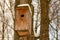 Wooden birdhouse old cracked snow-covered vertical photo house for bird protection help