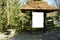 Wooden Blank board under the brick roof vegetated tree habitat rocky path