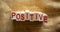 Wooden block form the text `positive` on beautiful canvas background