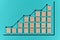 Wooden block statistics histogram with graph showing growth trend on blue paper background