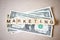 Wooden block word marketing and Dollar banknote
