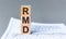 Wooden block with words RMD - acronim RMD - Required Minimum Distributions