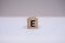 Wooden block written E with a white background.
