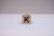 Wooden block written K with a white background.