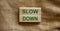 Wooden blocks form the text `slow down` on beautiful canvas background. Mindfulness concept
