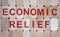 Wooden blocks form the words `economic relief`. Beautiful wooden background