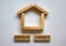 Wooden blocks form the words `estate owner` near miniature house. Beautiful white background, copy space. Business concept