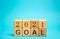 Wooden blocks with the inscription 2021 goal. The concept of achieving business goals. Execution of a business plan.