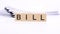 wooden blocks with text BILL on white table, stack white paper on background