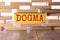 Wooden blocks with the text: dogma. Dogma word made with building blocks, business concept