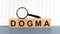 Wooden blocks with the text: dogma with magnifying glass