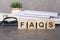 wooden blocks with text FAQS on black table