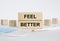 Wooden blocks with text Feel Better with mask and thermometer