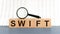 Wooden Blocks with the text: SWIFT with magnifying glass