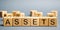 Wooden blocks with the word Assets. Resource owned by the business. Financial accounting. Money and finance. Cash equivalents,