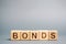 Wooden blocks with the word Bonds. A bond is a security that indicates that the investor has provided a loan to the issuer.