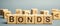 Wooden blocks with the word Bonds. A bond is a security that indicates that the investor has provided a loan to the issuer.