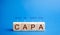 Wooden blocks with the word CAPA. Corrective and Preventive action plans. Business management concept. Strategy and efficiency.