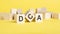 wooden blocks with word dca on yellow background. dollar cost averaging concept