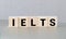 Wooden blocks with the word IELTS - international standardised test of English language