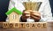 Wooden blocks with the word Mortgage and money in the hands of a businessman. The concept of buying a home on credit. Loan for