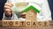 Wooden blocks with the word Mortgage and money in the hands of a businessman. The concept of buying a home on credit. Loan for