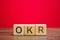 Wooden blocks with the word OKR  Objectives and Key Results . Team and individual goals. Effective control over the