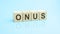 wooden blocks with the word ONUS, blue background