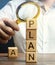 Wooden blocks with the word Plan and magnifying glass in the hands of a businessman. Strategy planning. Management business