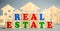 Wooden blocks with the word Real estate and wooden houses. Market value and real estate analytics. Pricing. Construction industry