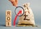 Wooden blocks with the word ROI and the up arrow with the money bag. High level of business profitability. Return on investment,