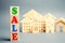 Wooden blocks with the word Sale and wooden miniature houses. The concept of the sell of real estate, apartments and residential