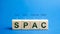 Wooden blocks with the word SPAC - Special purpose acquisition company. Simplified listing of company, merger bypassing stock