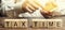 Wooden blocks with the word Tax time and taxpayer with a calculator. The concept of paying the tax rate. Taxation / burden. Pay
