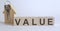 Wooden blocks with the word VALUE , house. The concept of the high cost of rent for an apartment or home. Interest rates are