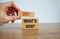 Wooden blocks with words `2021 whats new`. Beautiful wooden table, white background, male hand. Copy space. Business concept