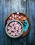 Wooden and blue bowl with pink flowers and water, scoop with sea salt on old background