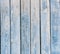 Wooden blue faded shabby vertical planks of an old fence as an abstract rural background.