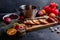 The wooden board with apples, a saucepan, a plate with cranberries and several red candles. Side view.