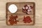 A wooden board with delicacies on which pieces of cheese and various types of meat lie, on the kitchen counter, top view.