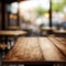 Wooden board empty table in front of a blurred background. Perspective brown wood over blurred cafe