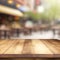 Wooden board empty table in front of a blurred background. Perspective brown wood over blurred cafe