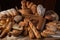 wooden board filled with various types of bread including baguettes, buns and rolls