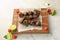Wooden board with juicy meat on barbecue skewers and sauce on table
