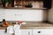 Wooden board with knife, tomatoes on modern kitchen countertop a